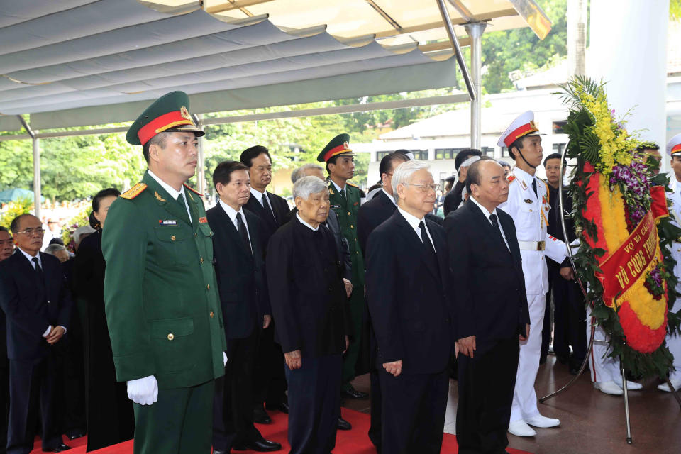 Vietnamese Communist Party General Secretary Nguyen Phu Trong, front left, and Prime Minister Nguyen Xuan Phuc, center right, pay tribute to late Vietnamese President Tran Dai Quang in Hanoi, Vietnam, Wednesday, Sept. 26, 2018. Hundreds of mourners are paying tribute to the president who died of viral illness last week. (Duong Van Giang/Vietnam News Agency via AP)