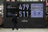 A man walks past a countdown display for the Tokyo 2020 Olympics and Paralympics Tuesday, March 31, 2020, in Tokyo. The countdown clock is ticking again for the Tokyo Olympics. They will be July 23 to Aug. 8, 2021. The clock read 479 days to go. This seems light years away, but also small and insignificant compared to the worldwide fallout from the coronavirus. (AP Photo/Jae C. Hong)