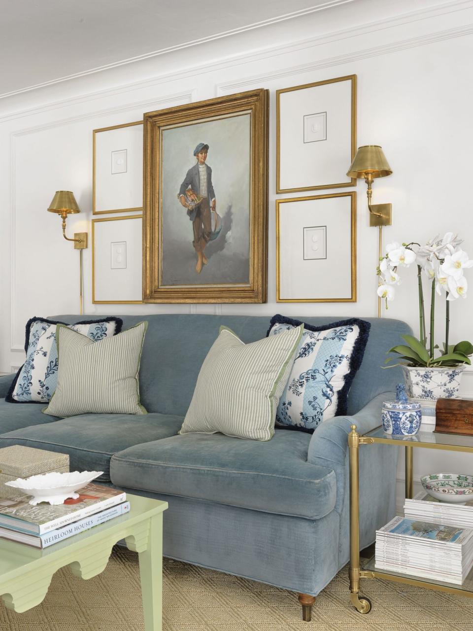Living Room with Blue Velvet Couch, Gold Sconces, and Orchid