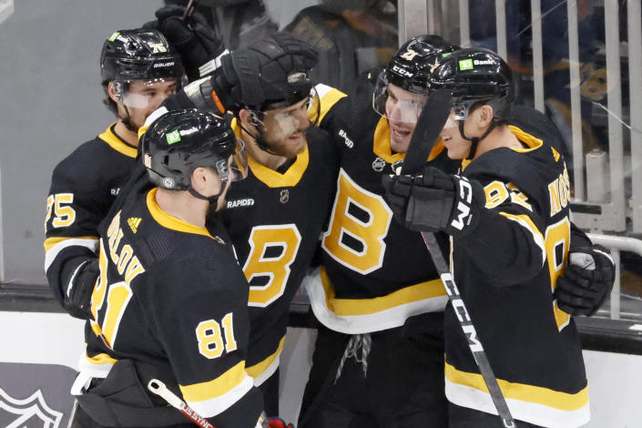 Boston Bruins players congratulate teammate Garnet Hathaway (21) after he scored the game-winning goal against the Detroit Red Wings during the third period of an NHL hockey game, Saturday, March 11, 2023, in Boston. (AP Photo/Mary Schwalm)