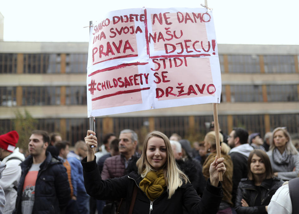 A woman holds a banner that reads "Every Child has its rights - Shame on the State" during a protest joined by up to a thousand people in Sarajevo, in Sarajevo, Bosnia, Thursday, Nov. 21, 2019. Protesters in Bosnia have rallied outside the government building in Sarajevo after opposition lawmaker Sabina Cudic published shocking photos of special needs children tied to beds and radiators in a nearby government facility. The protest Thursday by 1,000 people included scores of parents of children with disabilities, who described a dysfunctional care system that condemns their kids to suffering and excludes them from society. (AP Photo/Almir Alic)