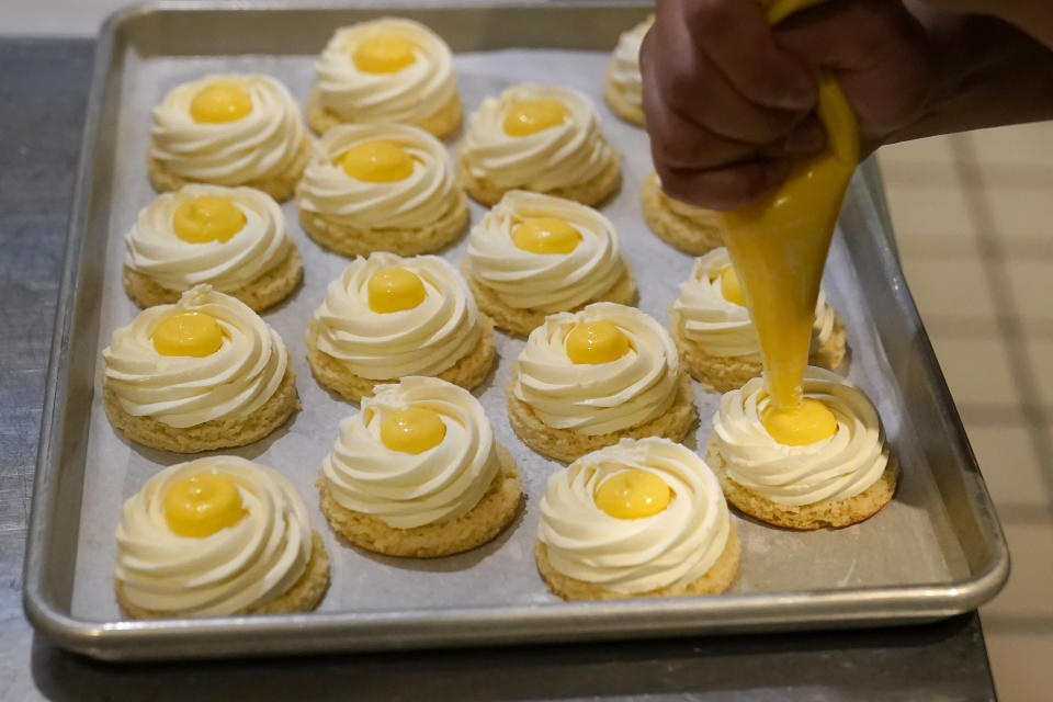 Pastry chef Vince Bugtong prepares Yema Cakes, a salted egg cake with almond yogurt and salted egg yolk custard, at Abaca restaurant in San Francisco, Monday, May 15, 2023. Three Filipino restaurants in three different areas of the U.S. will be representing at this year's James Beard Awards, the culinary world's equivalent of the Oscars. The awards ceremony is next week in Chicago. (AP Photo/Jeff Chiu)
