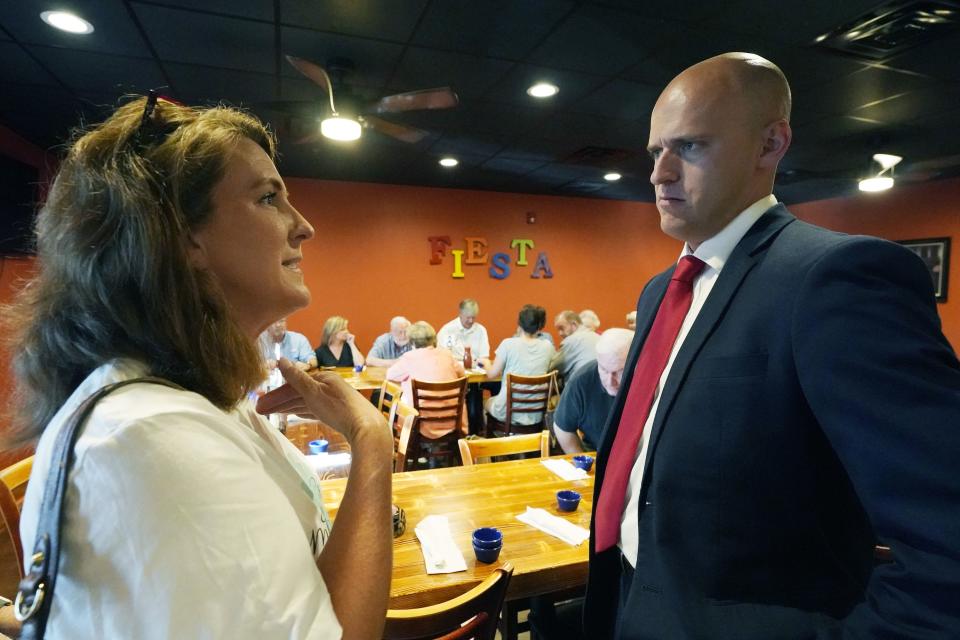 Former Navy pilot Michael Cassidy speaks to potential voter Heather Berry in Magee, Miss., June 15, 2022. Cassidy, a Republican running for the Mississippi House of Representatives is facing charges after being accused of destroying a Satanic Temple display inside the Iowa Capitol. | Rogelio V. Solis, Associated Press