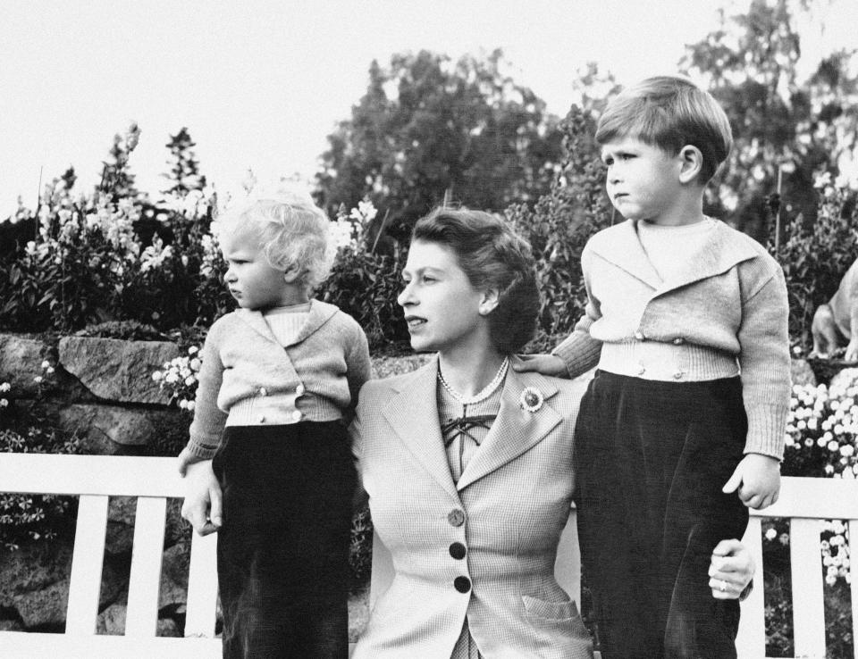 FILE - In this Nov. 14, 1952, photo, Britain's Queen Elizabeth II, poses for a photo with her children, Prince Charles and Princess Anne, in the grounds of Balmoral Castle, Scotland. When the hearse carrying Queen Elizabeth II's body pulled out of the gates of Balmoral Castle on Sunday, Sept. 11, 2022, it marked the monarch's final departure from a personal sanctuary where she could shed the straitjacket of protocol and ceremony for a few weeks every year. The sprawling estate in the Scottish Highlands west of Aberdeen was a place where Elizabeth rode her beloved horses, picnicked, and pushed her children around the grounds on tricycles and wagons, setting aside the formality of Buckingham Palace. (AP Photo, File)