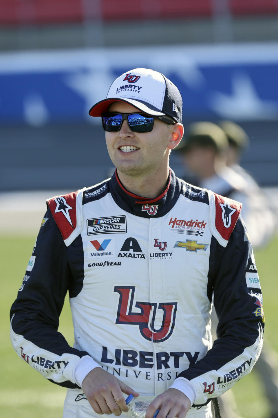 FILE - NASCAR Cup Series driver William Byron walks to his car before a NASCAR Cup Series auto race at Charlotte Motor Speedway in Concord, N.C., in this Sunday, May 30, 2021, file photo. Liberty University has reached a five-year extension with Hendrick Motorsports to continue as a primary sponsor for William Byron. Byron is a junior pursuing a degree in strategic communication through Liberty University’s online program.(AP Photo/Nell Redmond, File)