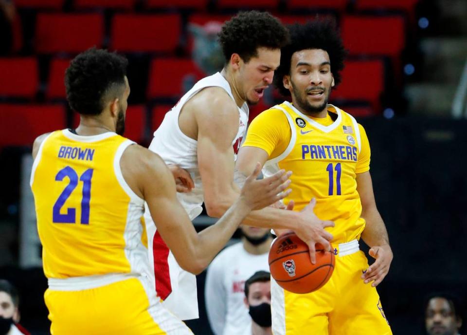 N.C. State’s Jericole Hellems (4) fights for a rebound between Pittsburgh’s Terrell Brown (21) and Pittsburgh’s Justin Champagnie (11) during the first half of N.C. State’s game against Pittsburgh at PNC Arena in Raleigh, N.C., Sunday, February 28, 2021.