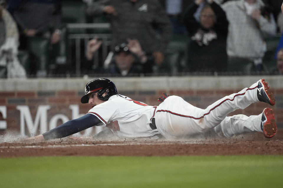 Atlanta Braves' Austin Riley scores on a Sean Murphy double in the sixth inning of a baseball game against the Cincinnati Reds, Monday, April 10, 2023, in Atlanta. (AP Photo/John Bazemore)