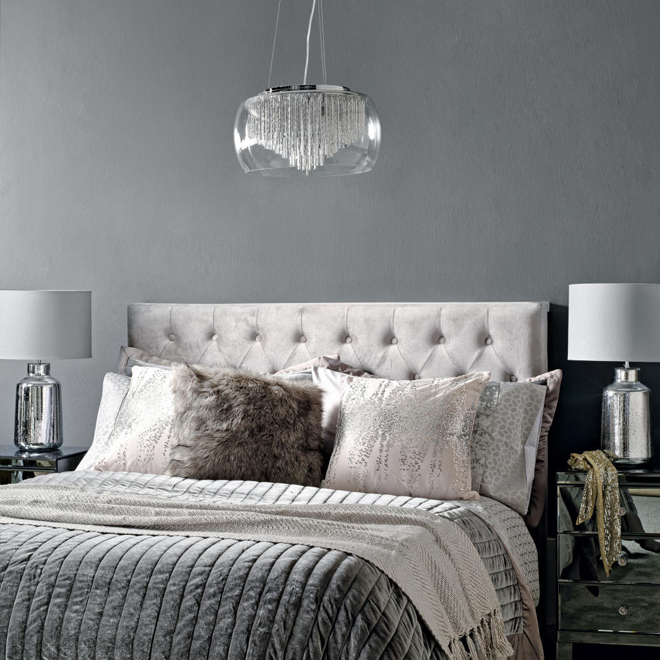 Glam grey bedroom with light grey upholstered headboard and glam bedside lights and pendant