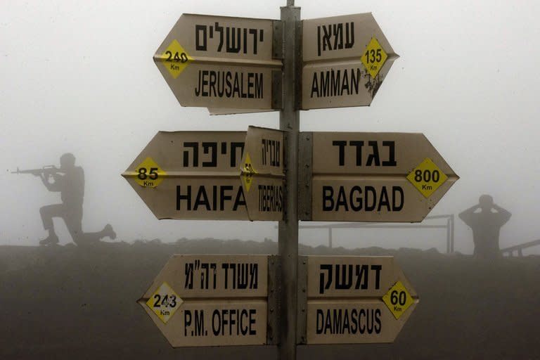 Statues of Israeli soldiers are seen next to a sign for tourists showing the different distances to Jerusalem, Baghdad, Damascus and other locations, at an army post in Mount Bental in the annexed Golan Heights on January 31, 2013. Israel carried out a rocket attack on the Jamraya scientific research centre in Damascus overnight, the official Syrian news agency SANA reported Sunday
