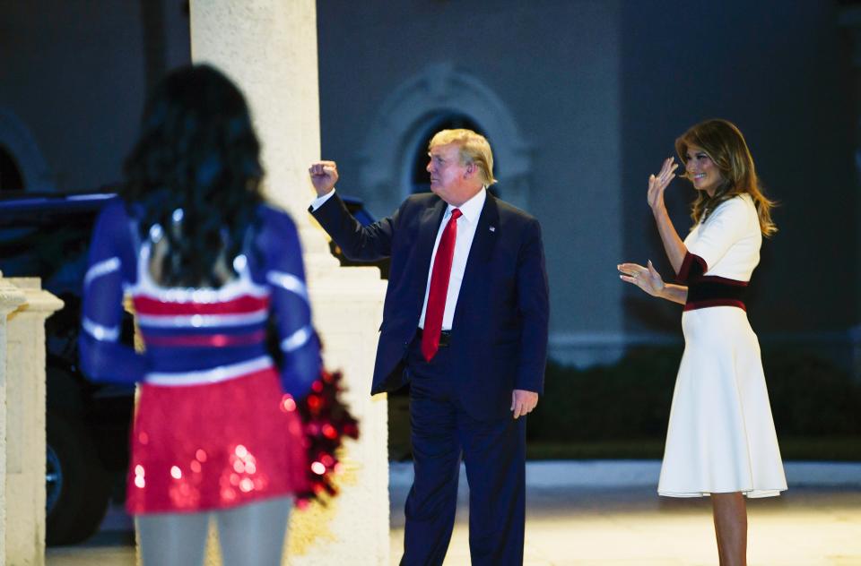 President Donald Trump and first lady Melania Trump watch as the Florida Atlantic University Marching Band performs during a Super Bowl party at the Trump International Golf Club in West Palm Beach, Fla., Feb. 2, 2020. She wore a white dress by Herve Pierre with navy-and-red waist and cuffs.