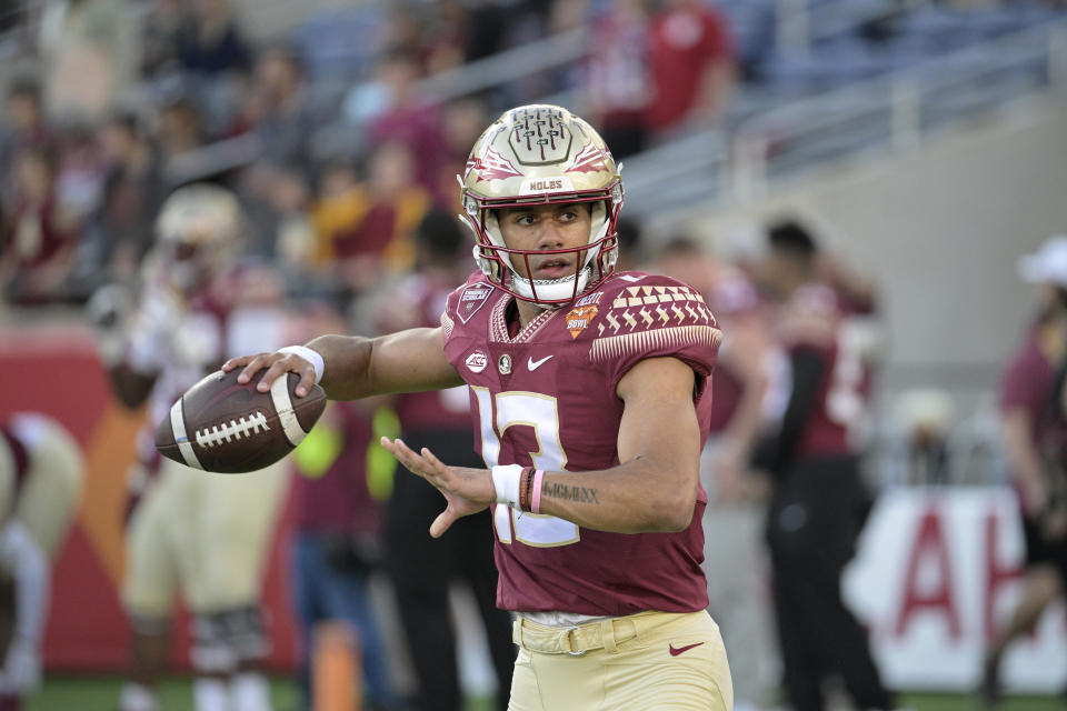 FILE - Florida State quarterback Jordan Travis (13) warms up before the Cheez-It Bowl NCAA college football game against Oklahoma, Thursday, Dec. 29, 2022, in Orlando, Fla. Florida State opens their season at home against LSU on Sept. 3. (AP Photo/Phelan M. Ebenhack, File)