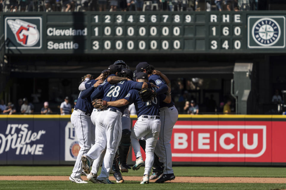 Seattle Mariners infielders, including third baseman Eugenio Suarez (28) and second baseman Adam Frazier, second from, right, celebrate after a baseball game against the Cleveland Guardians, Thursday, Aug. 25, 2022, in Seattle. (AP Photo/Stephen Brashear)