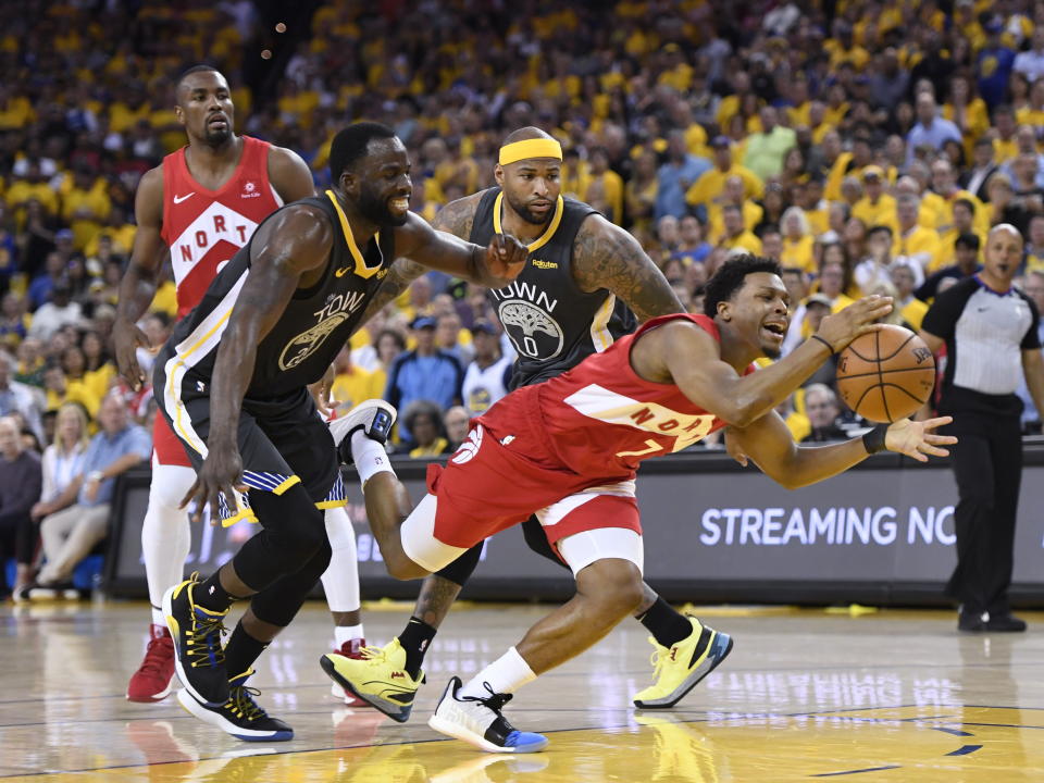 Toronto Raptors guard Kyle Lowry #7 reaches for the ball while under pressure from Golden State Warriors forward Draymond Green #23 and centre DeMarcus Cousins #0 during second half basketball action in Game 6 of the NBA Finals in Oakland, California on June 13, 2019. (Photo by The Canadian Press/Frank Gunn)