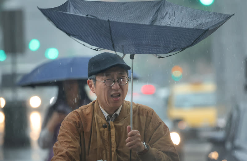 台北颳風有雨  民眾雨傘被吹開花 受鋒面影響，台北市區26日中午一度降下大雨、颳起 強風，信義區有民眾撐傘走在街頭，手中雨傘被強風 吹開了花。 中央社記者王飛華攝  113年4月26日 