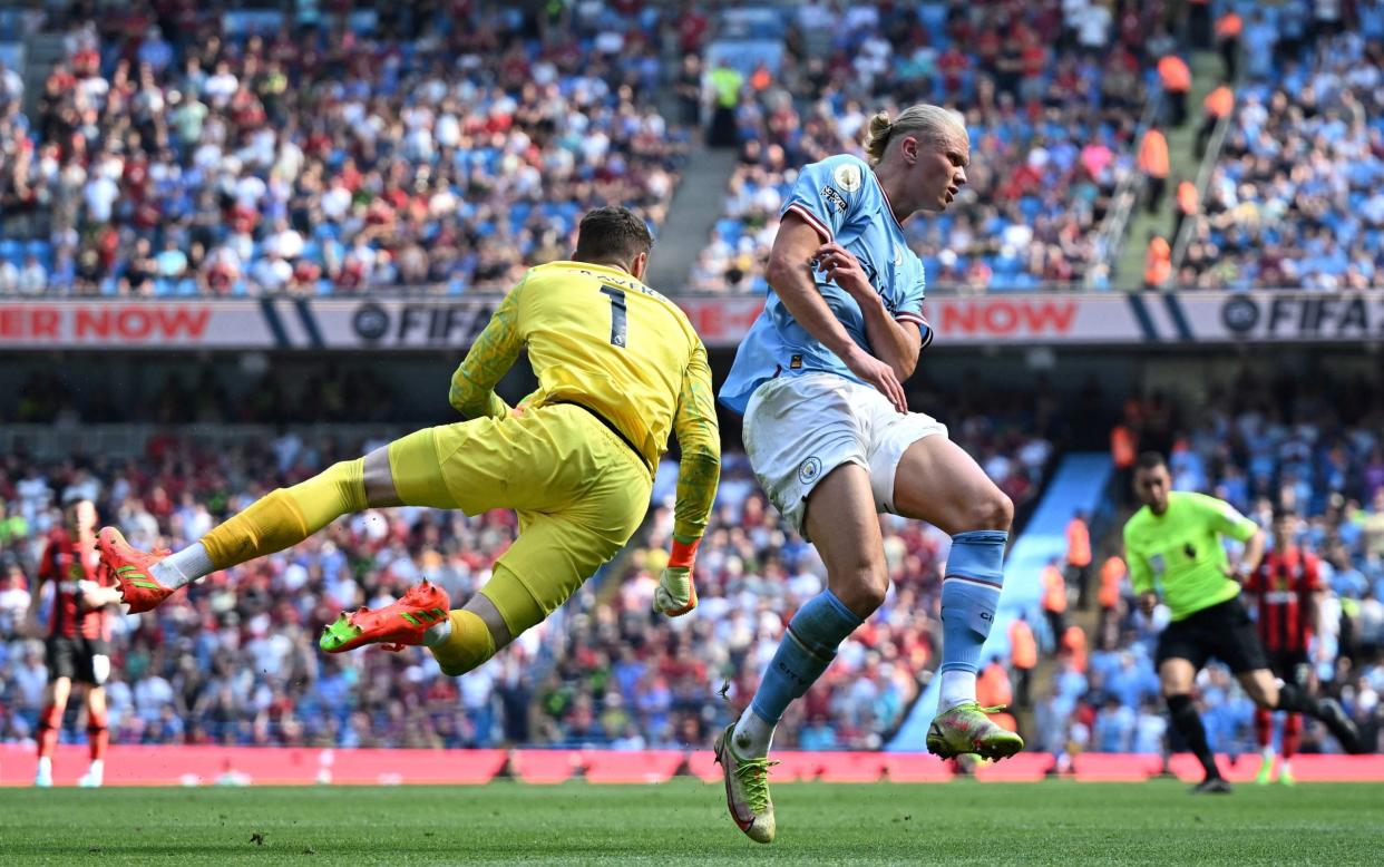 Bournemouth's Irish goalkeeper Mark Travers fights for the ball with Manchester City's Norwegian striker Erling Haaland - OLI SCARFF/AFP via Getty Images