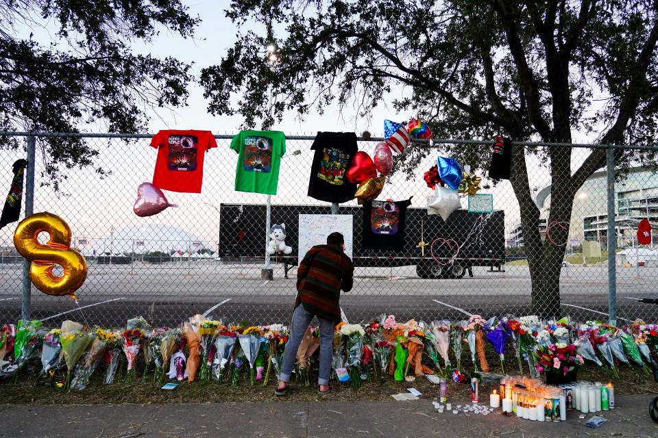 A visitor writes a note at a memorial outside the canceled Astroworld festival at NRG Park Sunday in Houston.