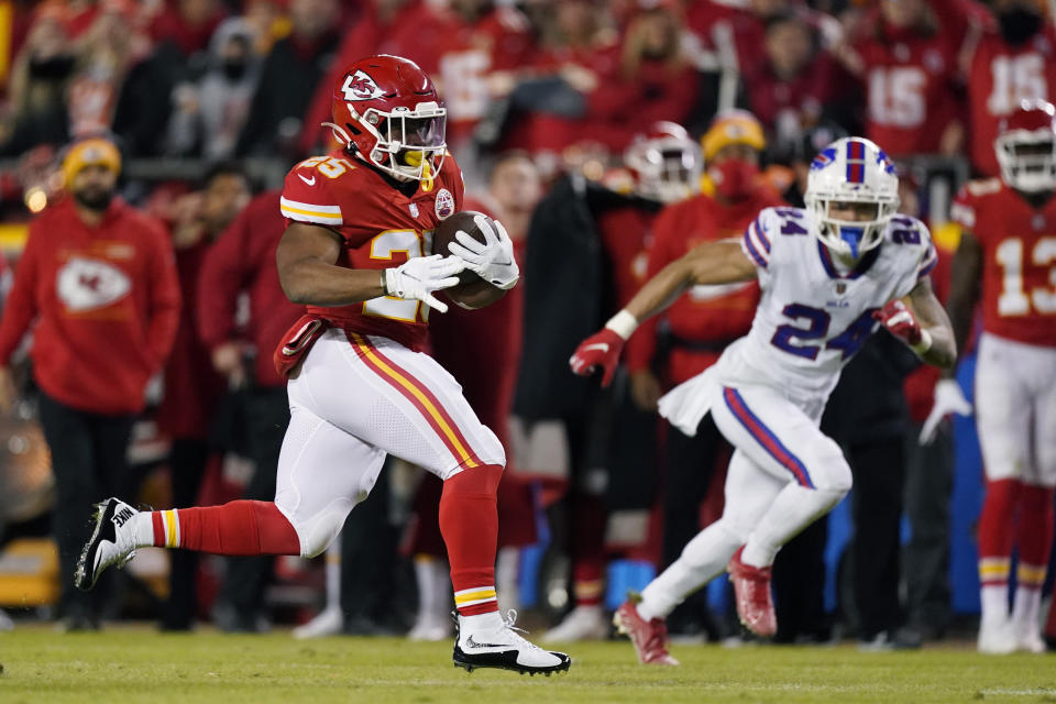 Kansas City Chiefs running back Clyde Edwards-Helaire (25) runs from Buffalo Bills cornerback Taron Johnson (24) during the first half of an NFL divisional round playoff football game, Sunday, Jan. 23, 2022, in Kansas City, Mo. (AP Photo/Charlie Riedel)