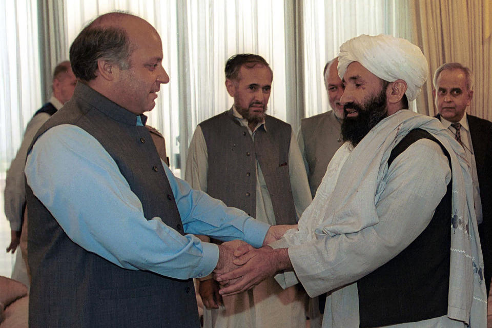 FILE - Mullah Hassan Akhund, right, then Afghanistan's Foreign Minister is received by then Pakistan Prime Minister Nawaz Sharif, in Islamabad, Aug. 25, 1999. (AP Photo/B.K. Bangash, File)