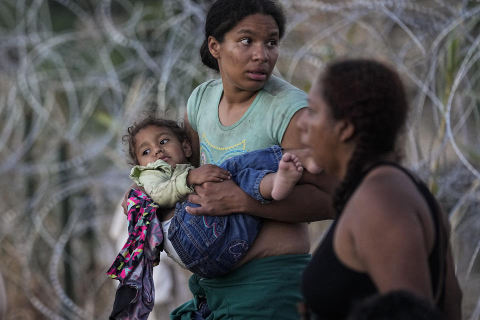 A woman carries her child after she and other migrants crossed the Rio Grande and entered the U.S. from Mexico, to be processed by U.S. Customs and Border Protection, Saturday, Sept. 23, 2023, in Eagle Pass, Texas. The image was part of a series by Associated Press photographers Ivan Valencia, Eduardo Verdugo, Felix Marquez, Marco Ugarte Fernando Llano, Eric Gay, Gregory Bull and Christian Chavez that won the 2024 Pulitzer Prize for feature photography. (AP Photo/Eric Gay)