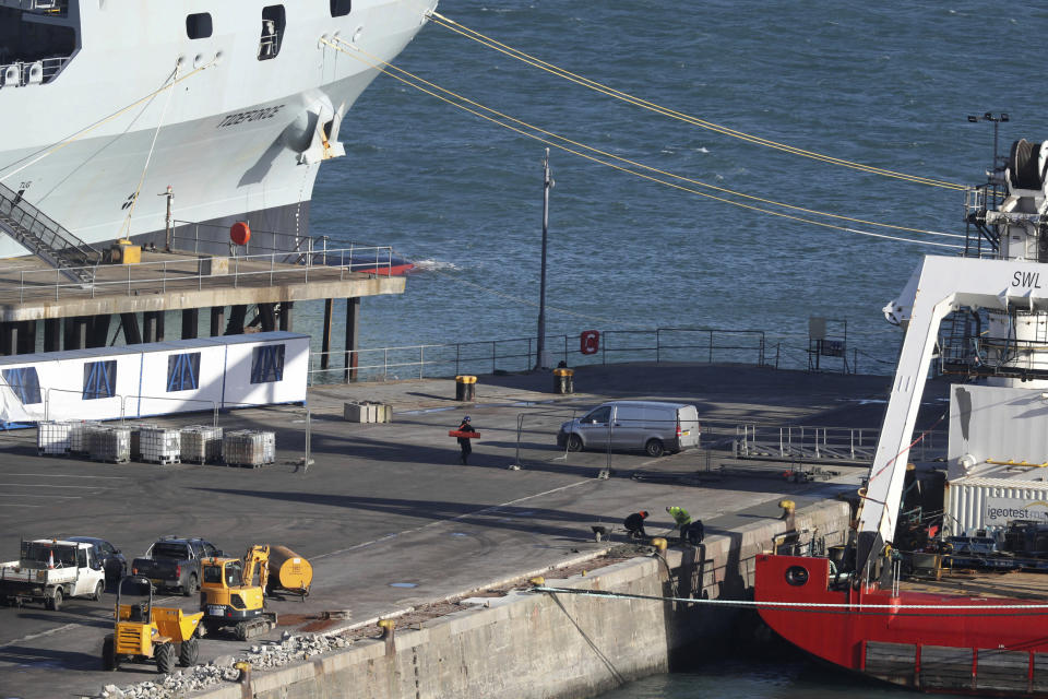 A van stands by the Geo Ocean III specialist search vessel, right, docked in Portland, England, which is carrying a body recovered from the wreckage of the plane carrying Cardiff City footballer Emiliano Sala and pilot David Ibbotson, Thursday Feb. 7, 2019. The aircraft remains 67 metres underwater 21 miles off the coast of Guernsey in the English Channel as poor weather conditions stopped recovery efforts. (Steve Parsons/PA via AP)