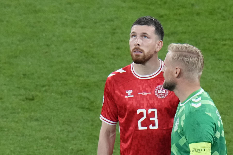 Denmark's Pierre-Emile Hojbjerg, left, looks up to the stadium roof during a round of sixteen match between Germany and Denmark at the Euro 2024 soccer tournament in Dortmund, Germany, Saturday, June 29, 2024. (AP Photo/Hassan Ammar)