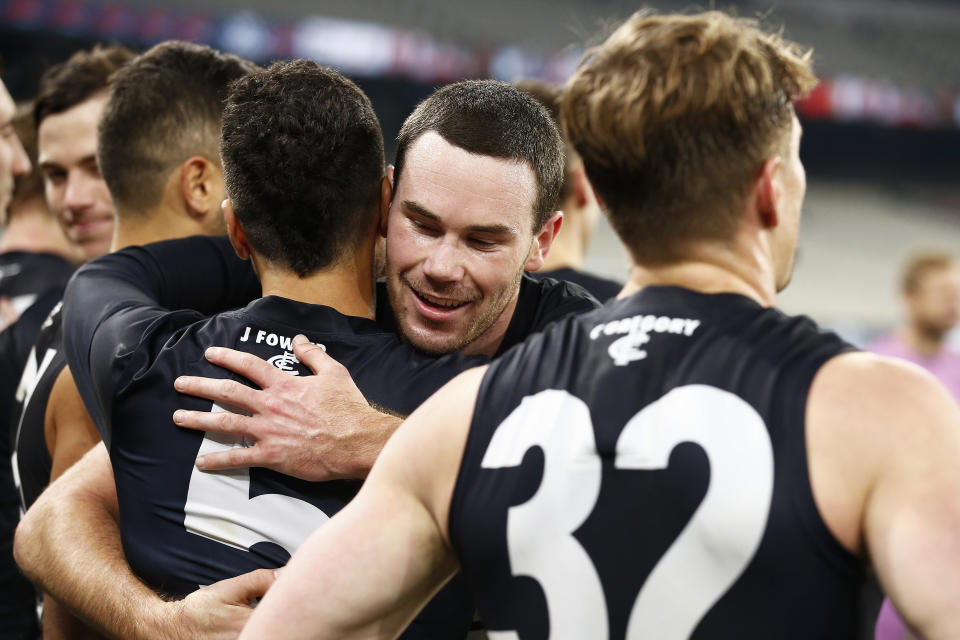 Blues players hug and celebrate after winning.