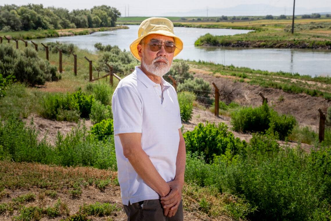 Ken Mochizuki, 69, whose parents were incarcerated at Minidoka, poses in front of reconstructed barbed wire fencing near the camp entrance.