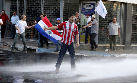 Protestors fight with the police during a demonstration against a possible change in the law to allow for presidential re-election in front of the Congress building in Asuncion, Paraguay, March 31, 2017. REUTERS/Jorge Adorno