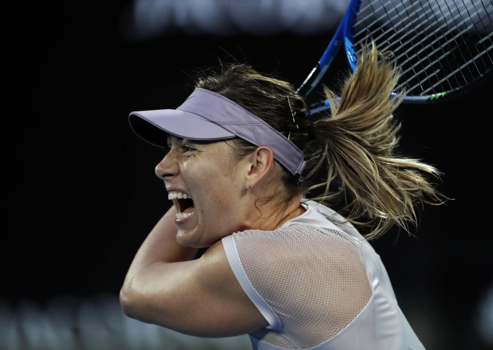 Russia’s Maria Sharapova makes a backhand return to Germany’s Angelique Kerber during their third round match at the Australian Open tennis championships in Melbourne, Australia, Saturday, Jan. 20, 2018. (AP Photo/Vincent Thian)