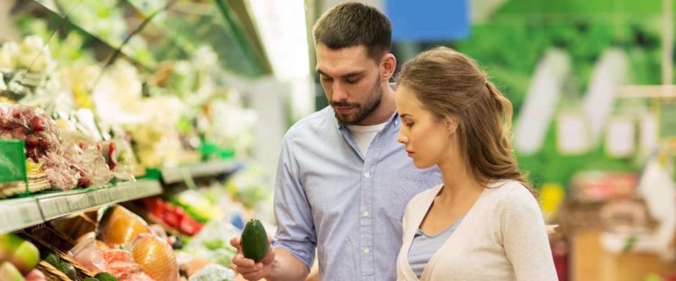 Couple shopping for produce at grocery store.