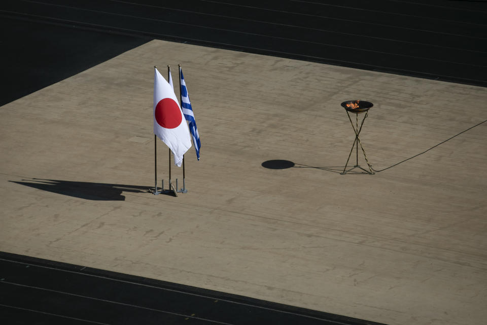The Japanese flag flies next to an altar with the Olympic Flame of the Tokyo 2020 Olympic Games, inside the Panathenian stadium, in Athens, Sunday, March 15, 2020. The Panathenian Stadium will be closed to the spectators on Thursday, March 19 during the handover ceremony of the Olympic flame for the Tokyo 2020 Olympic Games as a precaution against the spread of the coronavirus. The vast majority of people recover from the new coronavirus. According to the World Health Organization, most people recover in about two to six weeks, depending on the severity of the illness. (AP Photo/Yorgos Karahalis)