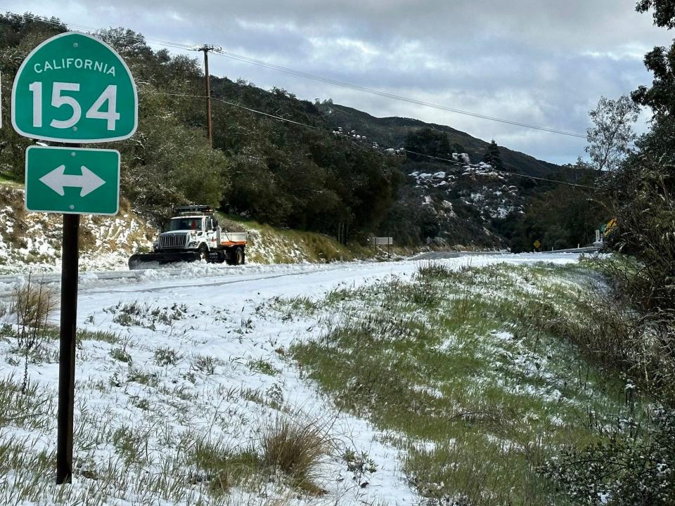 A snow plow clears snow along a highway in Santa Barbara County.