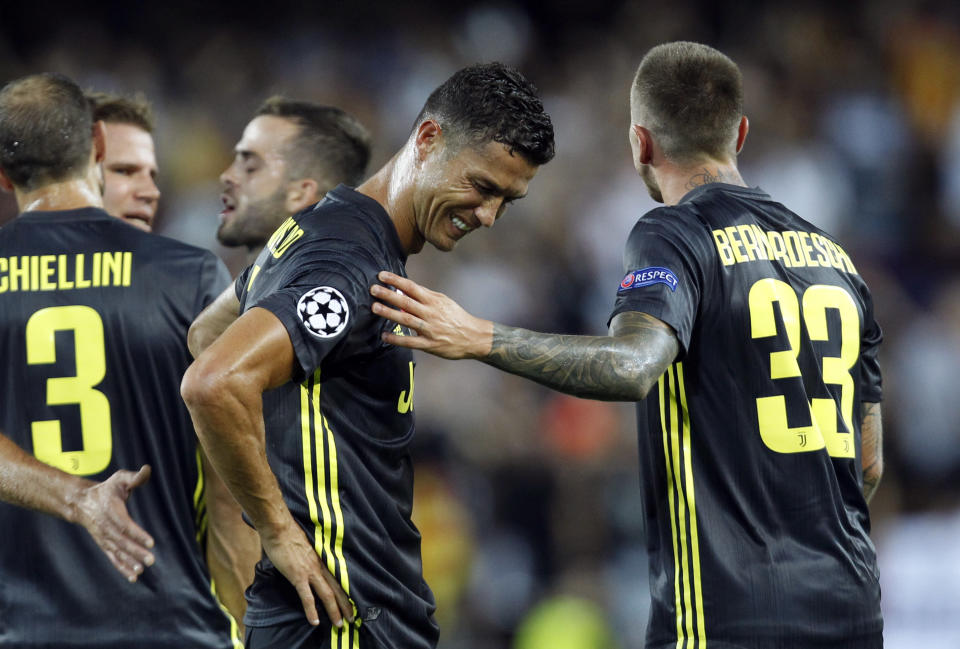 Juventus forward Cristiano Ronaldo is consoled by teammate Federico Bernardeschi, right, after receiving a red card during the Champions League, group H soccer match between Valencia and Juventus, at the Mestalla stadium in Valencia, Spain, Wednesday, Sept. 19, 2018. (AP Photo/Alberto Saiz)