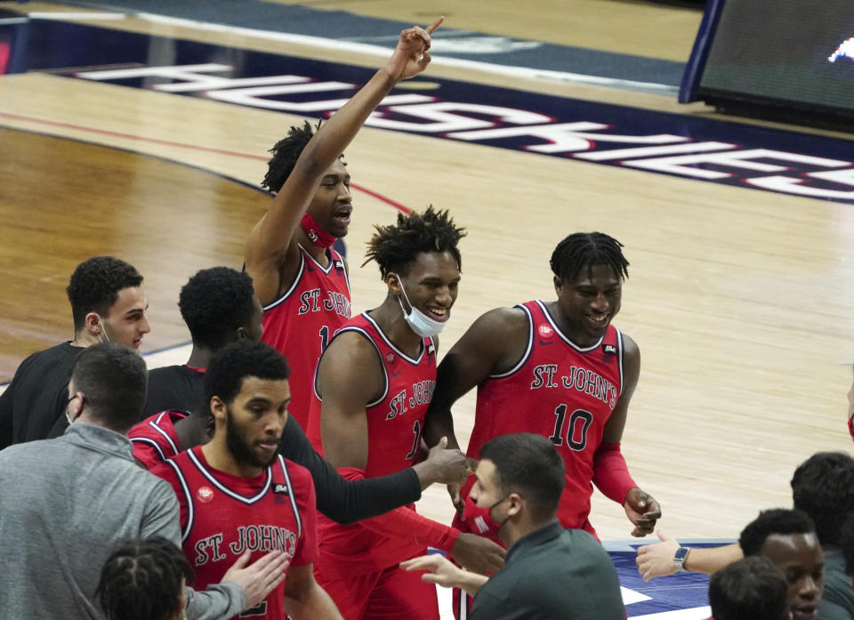 St. John's forwards Isaih Moore (13), Josh Roberts (1) and Marcellus Earlington (10) react after defeating Connecticut in an NCAA college basketball game in Storrs, Conn., Monday, Jan. 18, 2021. (David Butler II/Pool Photo via AP)