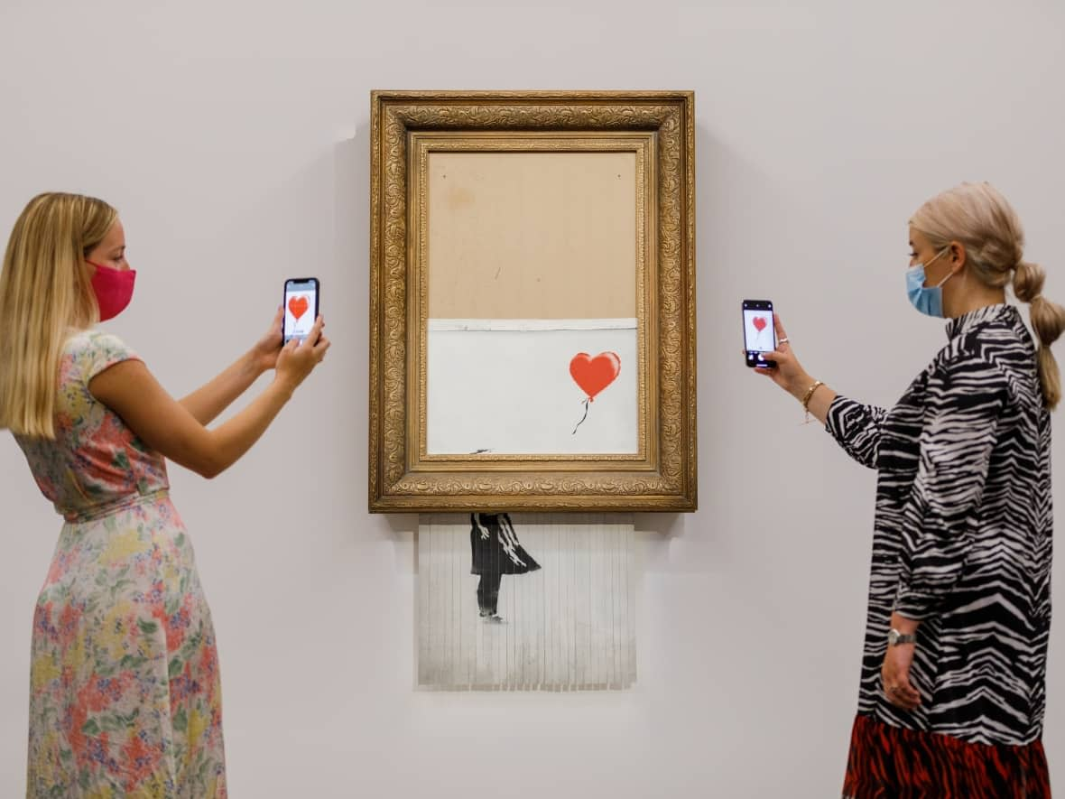 Banksy's Love is in the Bin is installed at Sotheby's on Sept 3, 2021 in London, England. The artwork, which famously shredded itself at an auction three years ago, sold again on Thursday for over $30 million Cdn.  (Tristan Fewings/Getty Images - image credit)