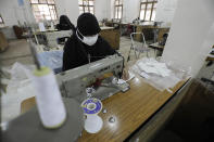 Yemeni women work to manufacture protective face masks, that are in high demand worldwide due the outbreak of the coronavirus, at a textile factory in Sanaa, Yemen, Tuesday, Mar. 17, 2020. For most people, the virus causes only mild or moderate symptoms. For some it can cause more severe illness. (AP Photo/Hani Mohammed)