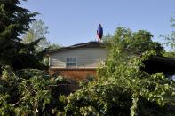 Preston Campbell surveys the damage from the roof of his father's home in Oklahoma City, Oklahoma May 7, 2015. About a dozen people were injured by a series of tornadoes that touched down southwest of Oklahoma City, part of a storm system that flattened structures and caused severe flooding in several Great Plain states, officials said on Thursday. REUTERS/Nick Oxford