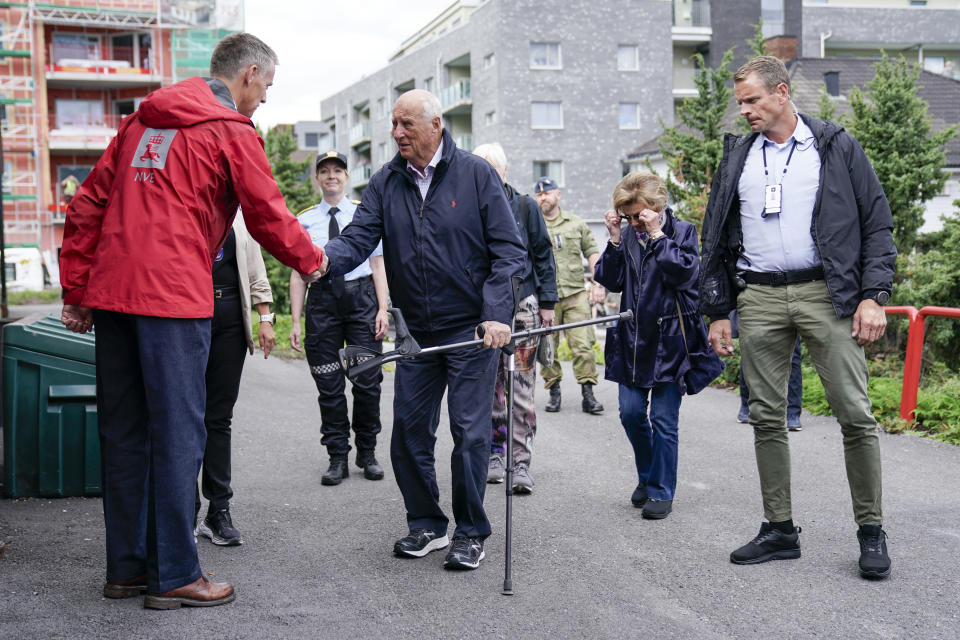 Norway's King Harald, center, and Queen Sonja visit Mjoendalen, Norway, Friday Aug. 11, 2023, to greet volunteers and get an overview of the flood area in the Drammensvassdraget. Authorities were on standby to evacuate more people in southeastern Norway Friday, where huge amounts of water, littered with broken trees, debris and trash, were thundering down the usually serene rivers after days of torrential rain. (Stian Lysberg Solum/NTB via AP)
