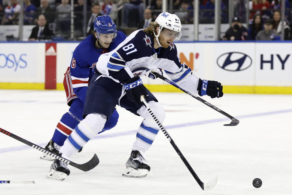 Winnipeg Jets left wing Kyle Connor (81) controls the puck past New York Rangers defenseman Jacob Trouba in the second period of an NHL hockey game Monday, Feb. 20, 2023, in New York. (AP Photo/Adam Hunger)
