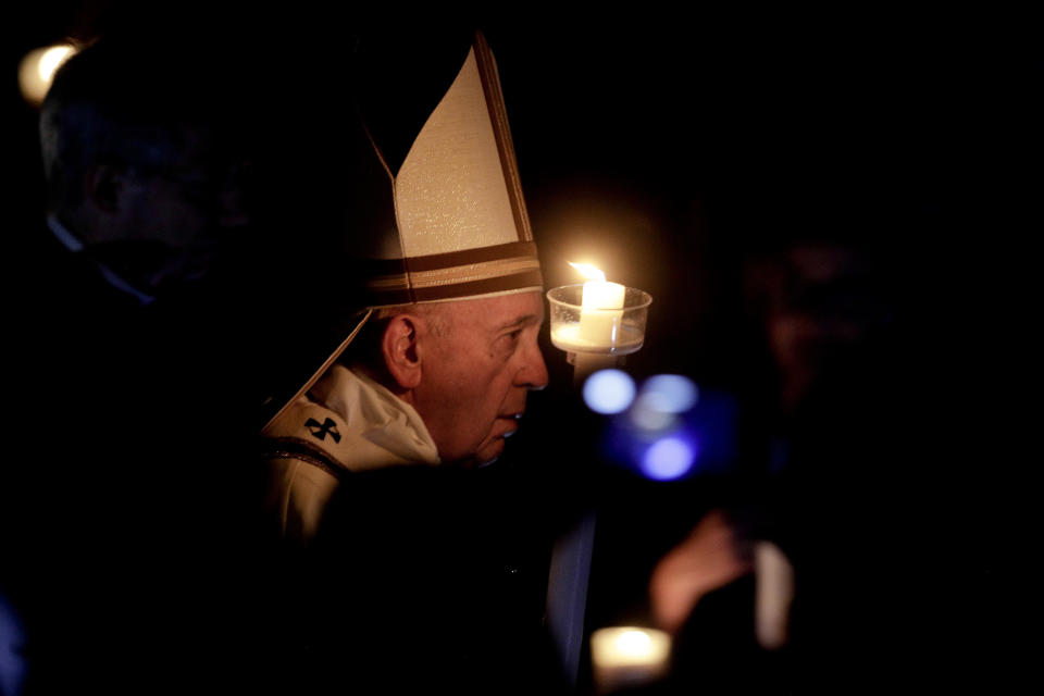 Pope Francis holds a candle as he presides over a solemn Easter vigil ceremony in St. Peter's Basilica at the Vatican, Saturday, April 21, 2019. (AP Photo/Gregorio Borgia)