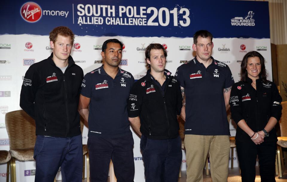 Britain's Prince Harry, left, the Expedition Patron, poses with from left, Ibrar Ali, Guy Disney and Kate Philp, members of the Walking With The Wounded South Pole Allied Challenge 2013 team following a welcome home news conference, in central London, Tuesday, Jan. 21, 2014. The Walking With The Wounded Virgin Money South Pole Allied Challenge 2013 concluded on Friday 13 December, when three teams of wounded servicemen and women successfully reached the South Pole after crossing 200km of Antarctic plateau. (AP Photo/Lefteris Pitarakis, Pool)