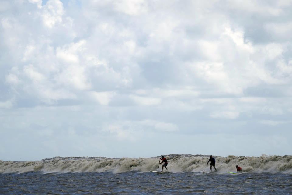Brazilians surfers ride the tidal bore wave known as "Pororoca," during the Amazon Surf Festival held in the Canal do Perigoso, or "Dangerous Channel," at the mouth of the Amazon River near Chaves, Marajo Island archipelago, Para state, Brazil, Monday, June 5, 2023. The Pororoca, a word from an Amazonian Indigenous dialect that means "destroyer" or "great blast," happens twice a day when the incoming ocean tide reverses the river flow for a time. (AP Photo/Eraldo Peres)