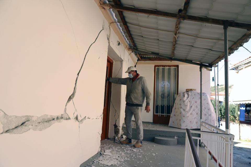 A man checks a house after an earthquake in Damasi village, central Greece, Wednesday, March 3, 2021. An earthquake with a preliminary magnitude of up to 6.3 struck central Greece on Wednesday and was felt as far away as the capitals of neighboring Albania, North Macedonia, Kosovo and Montenegro. (AP Photo/Vaggelis Kousioras)