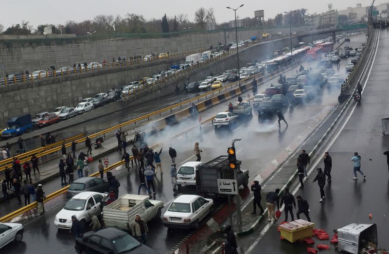 FILE PHOTO: People protest against increased gas price, on a highway in Tehran