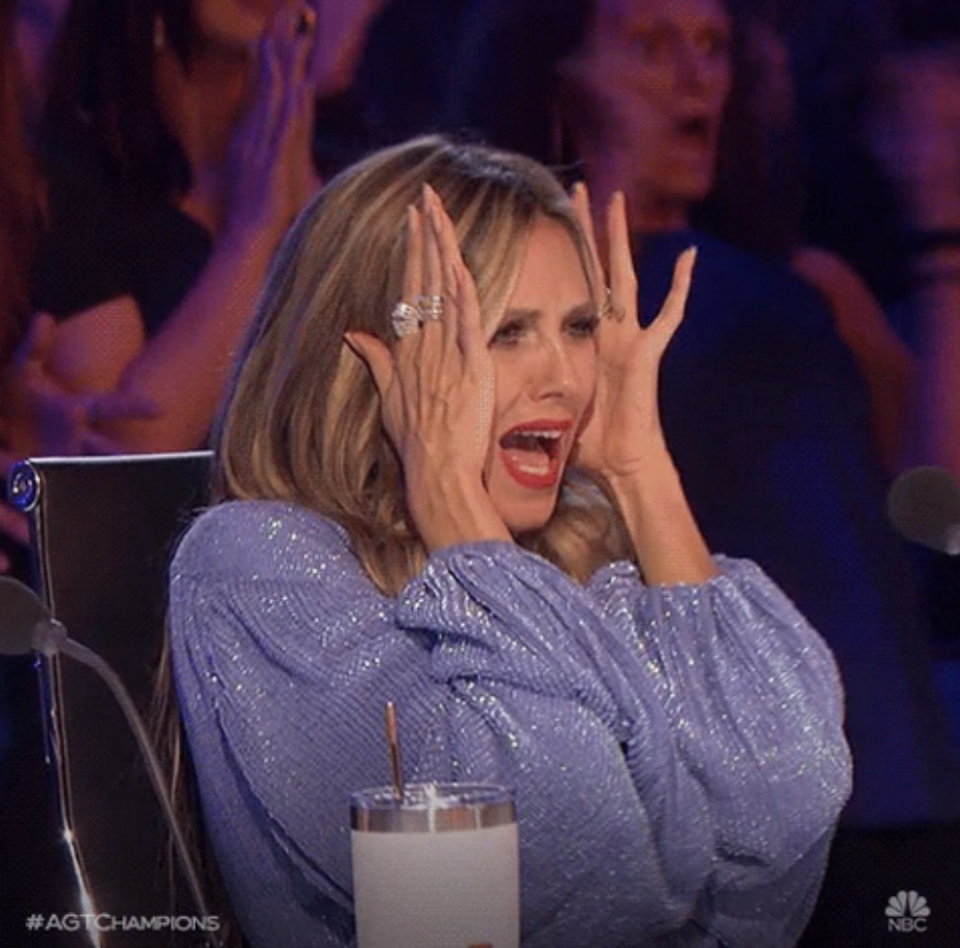 Heidi Klum with her hands to her face, looking like she's screaming