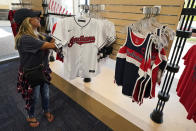 Julie Howe looks at Cleveland Indians apparel in the Indians team shop before a baseball game, Monday, Sept. 27, 2021, in Cleveland. Cleveland will play its final home game against the Kansas City Royals as the Indians, the team's nickname since 1915. The club will be called the Cleveland Guardians next season. (AP Photo/Tony Dejak)