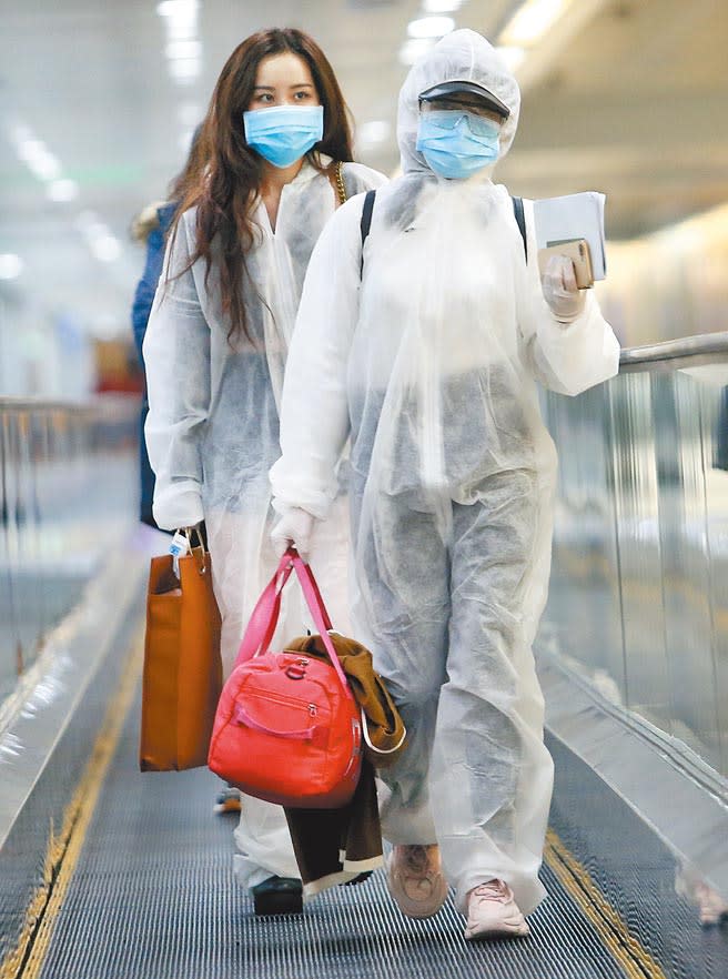 中央流行疫情指揮中心11日公布國內新增1例境外移入新冠肺炎確定病例，在桃園機場入境管制區內，2名身穿防護衣的旅客正準備通關入境。（范揚光攝）