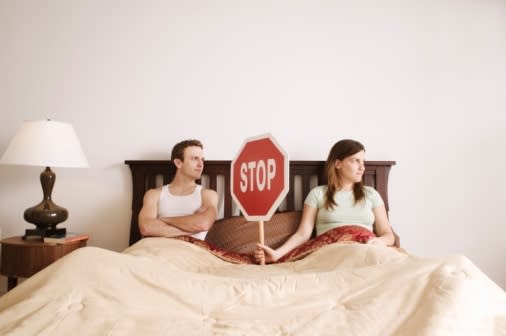 Couple in bed with stop sign