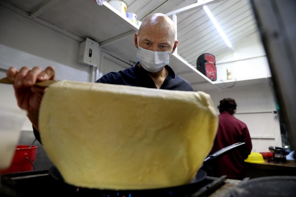 Professional wrestler Joel Bernal Galicia, known as Olímpico, makes crepes at his wife's Crepas El Mana stand in Mexico City.