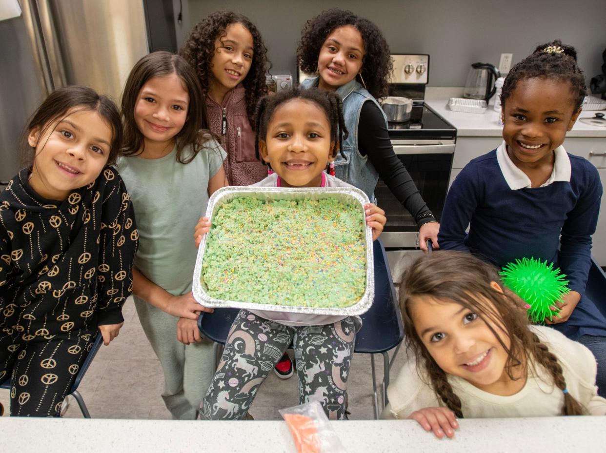 Students in kindergarten and first grade proudly display the tray of Rice Krispies treats they made during an after-school program Thursday at Girls Inc.